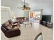 Spacious living room featuring comfortable leather seating, tile flooring, and a sliding glass door to the porch at 4214 Foxboro Dr, New Port Richey, FL 34653