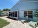 Inviting patio with two lounge chairs, perfect for relaxation, complemented by lush landscaping and a charming screened-in porch at 4214 Foxboro Dr, New Port Richey, FL 34653