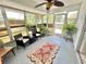 Relaxing sunroom featuring wicker furniture, large windows, and a decorative rug, creating a cozy and inviting space at 4214 Foxboro Dr, New Port Richey, FL 34653