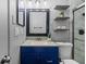 Bathroom featuring a blue vanity, granite countertop, framed mirror and tiled shower at 4226 4Th S Ave, St Petersburg, FL 33711