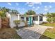 Cozy home exterior with a turquoise door, security bars, and a small concrete patio space at 4226 4Th S Ave, St Petersburg, FL 33711