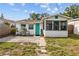 Cozy home exterior with a turquoise door, security bars, and a small brick patio space at 4226 4Th S Ave, St Petersburg, FL 33711