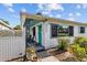 Inviting front entrance with teal door, decorative metal porch posts, and a cozy seating area at 4226 4Th S Ave, St Petersburg, FL 33711