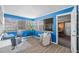 Bright sunroom with blue walls, gray chairs, white accent chair, and lots of windows at 4226 4Th S Ave, St Petersburg, FL 33711