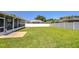 Large backyard showcasing a well-maintained lawn, screened-in patio, and privacy fence at 445 Arch Ridge Loop, Seffner, FL 33584
