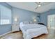 Comfortable bedroom featuring wood floors, a ceiling fan, and an ensuite bathroom at 445 Arch Ridge Loop, Seffner, FL 33584