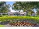 Community sign featuring lush greenery, blooming flowers and stone pillars at 445 Arch Ridge Loop, Seffner, FL 33584