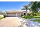 Charming home with a well-maintained lawn and a mature palm tree in the front yard at 445 Arch Ridge Loop, Seffner, FL 33584