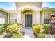 Close up of charming home's front entrance with colorful landscaping at 445 Arch Ridge Loop, Seffner, FL 33584