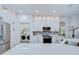 Well-lit kitchen featuring white cabinetry, stainless steel appliances, and convenient laundry access at 445 Arch Ridge Loop, Seffner, FL 33584
