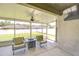 Screened-in patio with ceiling fan, backyard view, and TV at 445 Arch Ridge Loop, Seffner, FL 33584