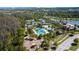 Community aerial view featuring tennis courts, a pool, clubhouse, parking, playground and a beautiful lake at 4652 San Martino Dr, Wesley Chapel, FL 33543