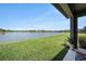 Green backyard with water view and a covered patio at 4652 San Martino Dr, Wesley Chapel, FL 33543