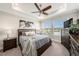 Beautiful bedroom features a tray ceiling, ceiling fan, and large windows overlooking the lake at 4652 San Martino Dr, Wesley Chapel, FL 33543
