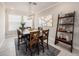 Bright dining room features a stylish light fixture, six-seat table and a decorative wooden ladder shelf at 4652 San Martino Dr, Wesley Chapel, FL 33543