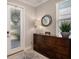 Elegant entryway with wood-look floors, stylish decor, a round mirror, and natural light at 4652 San Martino Dr, Wesley Chapel, FL 33543