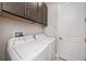 Functional laundry room equipped with a washer, dryer, and overhead cabinets for ample storage at 4652 San Martino Dr, Wesley Chapel, FL 33543