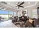 Spacious living room with a ceiling fan, tile floors, large windows showcasing scenic lake views, and leather furniture at 4652 San Martino Dr, Wesley Chapel, FL 33543