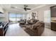 Bright living room with lake views, a ceiling fan, tile floors, and comfortable leather seating at 4652 San Martino Dr, Wesley Chapel, FL 33543