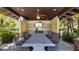 Covered outdoor dining area featuring a large table, seating, outdoor television and a functional serving area at 4652 San Martino Dr, Wesley Chapel, FL 33543