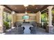Covered outdoor dining area featuring a large table, seating, outdoor television and a functional serving area at 4652 San Martino Dr, Wesley Chapel, FL 33543