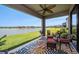 Covered patio with a ceiling fan, beautiful water view, and wicker furniture at 4652 San Martino Dr, Wesley Chapel, FL 33543