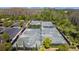 Aerial view of well-maintained tennis courts surrounded by lush greenery and landscaping with parking at 4652 San Martino Dr, Wesley Chapel, FL 33543