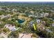 Wide aerial view of house surrounded by pond and trees in a residential neighborhood at 4702 W Heron Ln, Tampa, FL 33629
