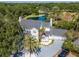 Stunning aerial view of the white house with a gray roof, circular driveway, and lush landscaping at 4702 W Heron Ln, Tampa, FL 33629