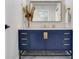Bathroom vanity features a blue cabinet with gold fixtures, a large mirror and marble floors at 4702 W Heron Ln, Tampa, FL 33629