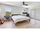 Bright bedroom featuring hardwood floors, a ceiling fan, and a large window offering views of the outdoors at 4702 W Heron Ln, Tampa, FL 33629