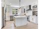 Modern white kitchen with stainless steel appliances, island, and wine rack at 4702 W Heron Ln, Tampa, FL 33629