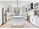 Modern white kitchen with stainless steel appliances, island, and wine rack at 4702 W Heron Ln, Tampa, FL 33629