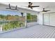Comfortable covered patio boasts gray wood-look flooring, ceiling fans, and serene views of surrounding greenery and a pond at 4702 W Heron Ln, Tampa, FL 33629