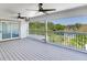 Spacious enclosed patio features gray wood-look flooring, ceiling fans and serene views of the nearby pond at 4702 W Heron Ln, Tampa, FL 33629