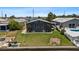 Landscaped backyard featuring a screened patio, lush grass, and canal access, perfect for outdoor living and entertaining at 5051 Bonito Dr, New Port Richey, FL 34652