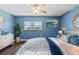 Comfortable bedroom featuring blue walls, a ceiling fan, natural light, and a cozy bed at 5051 Bonito Dr, New Port Richey, FL 34652