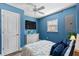 Cozy bedroom with blue walls, white dresser, and a mounted TV for ultimate relaxation at 5051 Bonito Dr, New Port Richey, FL 34652