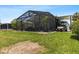 Exterior rear view of a property with a screened patio and a golf cart under a carport at 5051 Bonito Dr, New Port Richey, FL 34652
