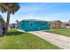 Brightly painted home features a lush lawn and a concrete driveway, creating a cheerful and inviting atmosphere at 5051 Bonito Dr, New Port Richey, FL 34652