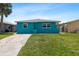 Charming single-story home featuring a well-manicured front yard and a vibrant blue exterior at 5051 Bonito Dr, New Port Richey, FL 34652