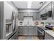 Modern kitchen featuring stainless steel appliances, gray cabinets, and white subway tile backsplash at 5051 Bonito Dr, New Port Richey, FL 34652