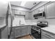 Stylish kitchen features modern appliances, gray cabinets, and white tile backsplash at 5051 Bonito Dr, New Port Richey, FL 34652
