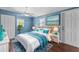 Bright and airy bedroom with white and blue decor, ceiling fan and plenty of light at 5051 Bonito Dr, New Port Richey, FL 34652