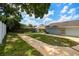 Grassy backyard with walkway, partial fencing, and mature trees offering shade at 509 Stone Dr, Brandon, FL 33510