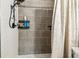Contemporary shower design with modern gray tile surround, convenient shelving, and rainfall shower head at 509 Stone Dr, Brandon, FL 33510