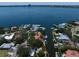 Aerial view of waterfront homes along a canal leading to a bay with a cityscape beyond at 514 Riviera Dr, Tampa, FL 33606