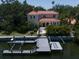 Waterfront home with dock featuring a boat lift, patio, and lush landscaping from above at 514 Riviera Dr, Tampa, FL 33606