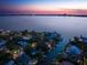 Aerial view of waterfront homes along a canal with the city skyline in the background at dusk at 514 Riviera Dr, Tampa, FL 33606