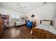 Cozy bedroom featuring hardwood floors, two twin beds, a ceiling fan and a large sunny window at 514 Riviera Dr, Tampa, FL 33606